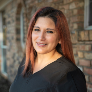 Claudia, Dental Assistant at our Plano dental office, grinning warmly in her headshot.