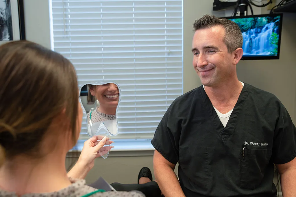 Dr. Simmons talking to a patient in a dental chair